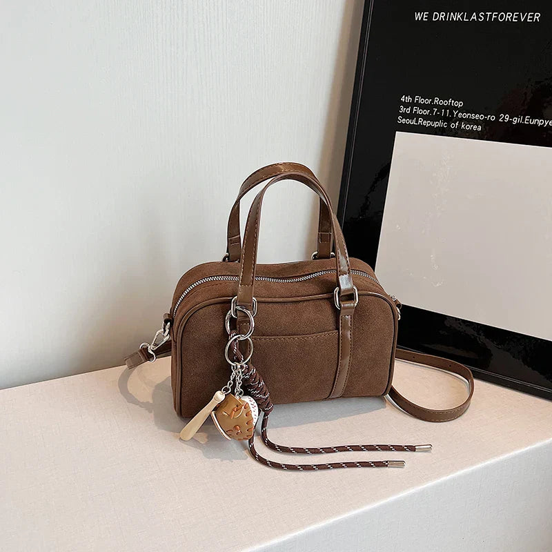 Sac bandoulière Alina en daim marron, chic et pratique, idéal pour transporter vos essentiels avec style.