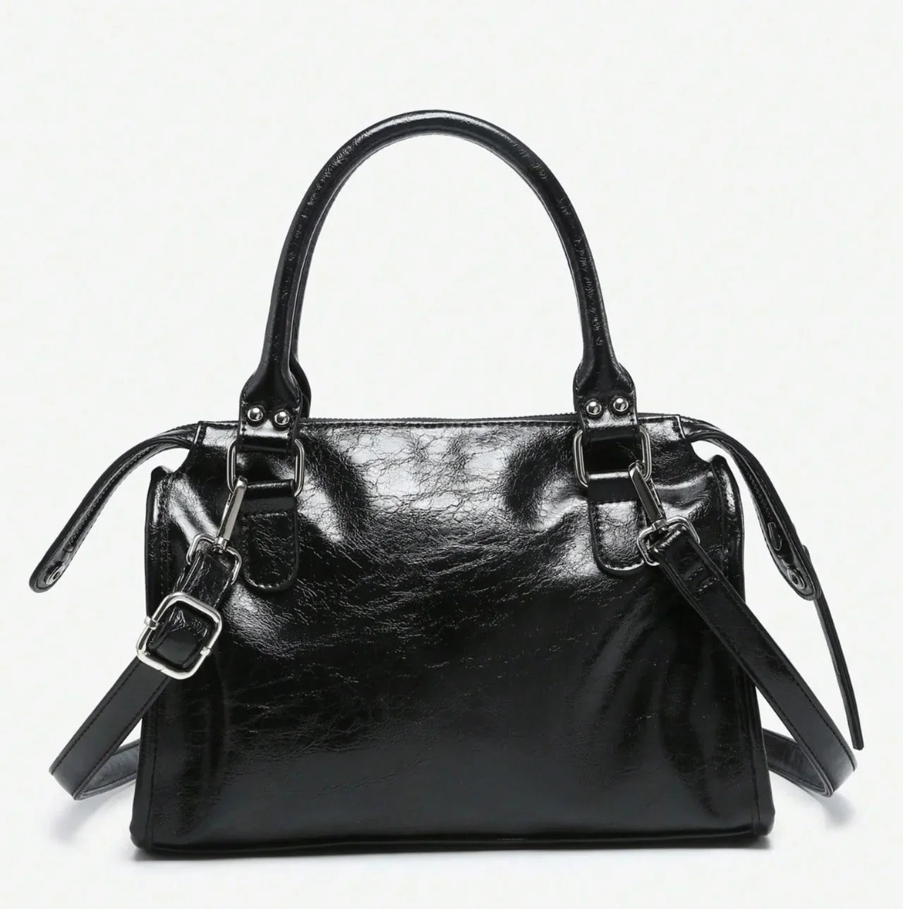 Sac à main CARLA en cuir noir effet brillant, avec détails métalliques, finitions soignées, anses solides, bandoulière réglable et grand compartiment zippé, parfait pour le travail et les sorties, vue dos.