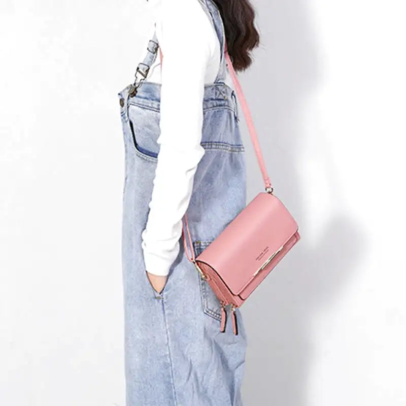 Sac à main CASSIE en cuir synthètique rose, bandoulière ajustable, avec rabat, compartiments et poches pour organiser vos essentiels avec style et praticité, porté en bandoulière.