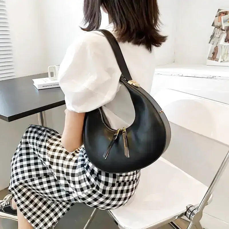 Sac à main femme Gloria noir en forme de demi-lune, élégant et compact, parfait pour vos sorties, rendez-vous ou soirées, chic, pratique et durable.