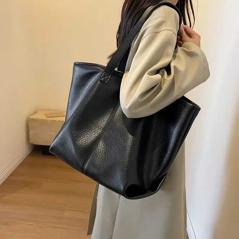 Sac à main KIM en cuir noir, moderne et pratique, grand sac tote bag avec intérieur spacieux et finitions soignées, parfait pour le quotidien et le travail, porté épaule.