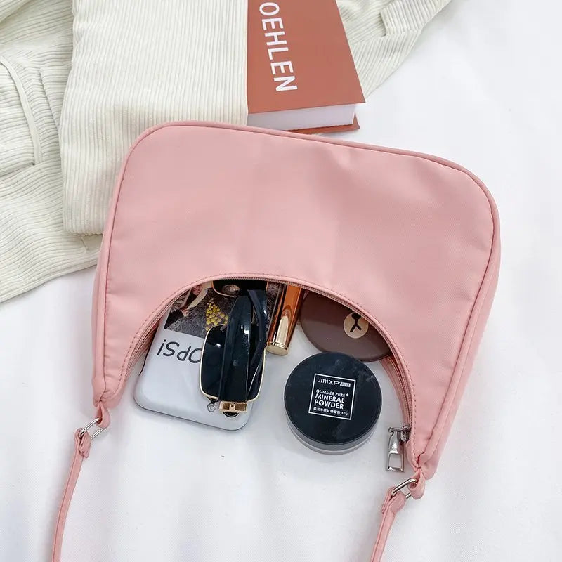 Petit sac à main MELIA en cuir souple rose format compact avec design chic et minimaliste, idéal pour une sortie élégante.